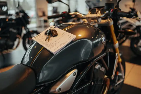 Glimmende nieuwe motorfiets in showroom met sleutels en verzekeringsdocument op de tank, chromen details in warm spotlicht.