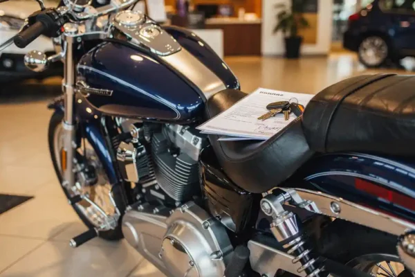 Glanzende motorfiets in showroom met getekend financieringscontract en sleutels op het lederen zadel, chromen details in warm spotlicht.